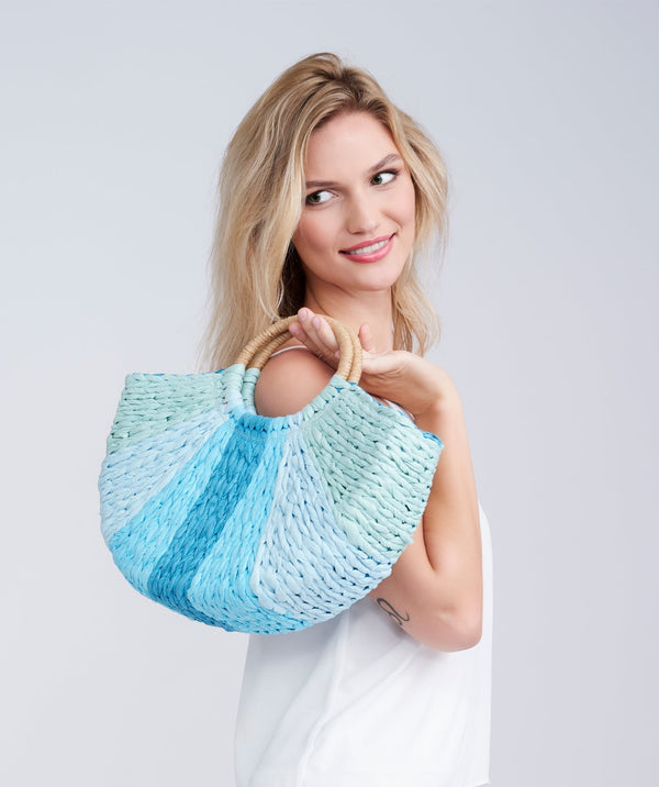 Straw semi-circular half-moon bag, top handles, zip closure, interior pockets, lightweight structured design for summer, beach and travel use.