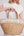 Straw beach basket bag in sand natural with floral sequin panel, zip closure, top handles, interior pockets, lightweight spacious design for beach and summer travel use.