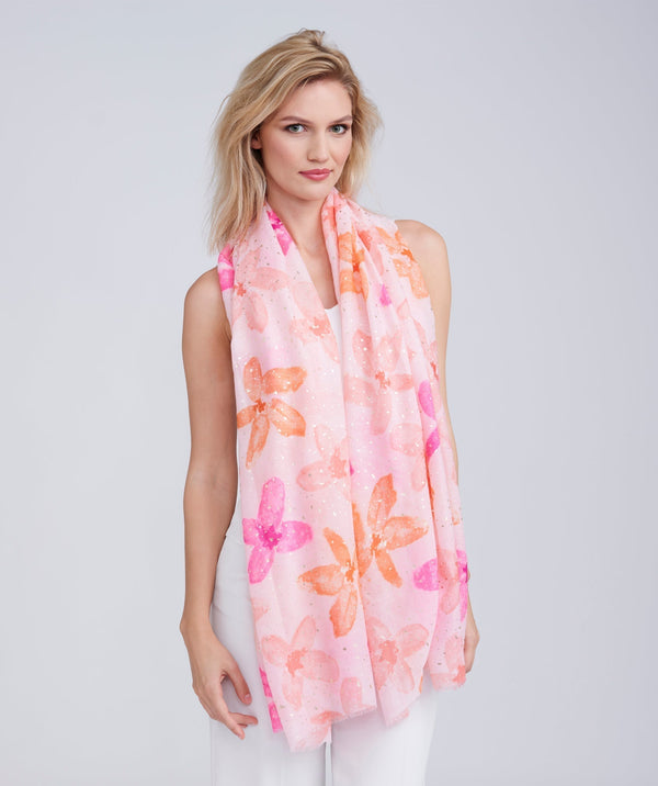 Light pink oblong summer scarf featuring a floral print with subtle lurex metallic detailing and delicate frayed hems. Made from soft, lightweight fabric with a smooth hand feel.
